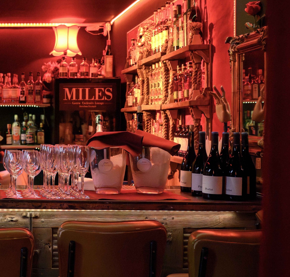 Bar de In Confidence — bouteilles, verres et logo Miles