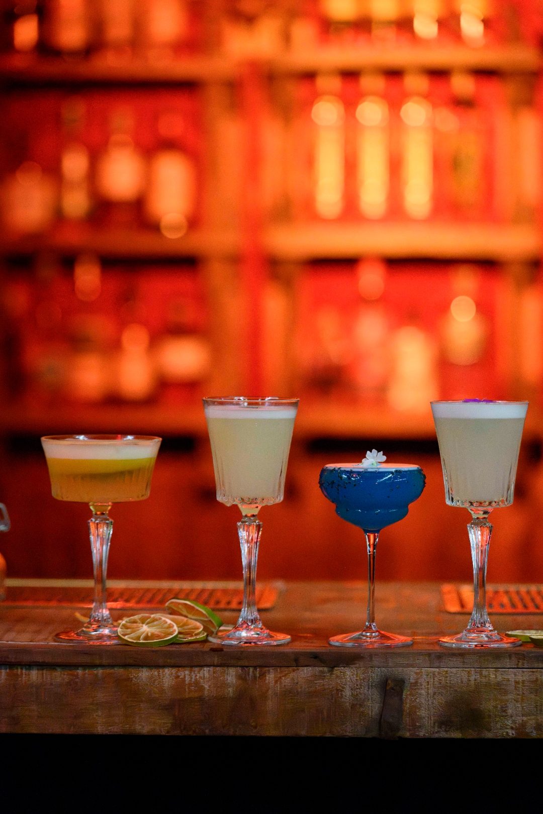 Cuatro cócteles de autor alineados en la barra