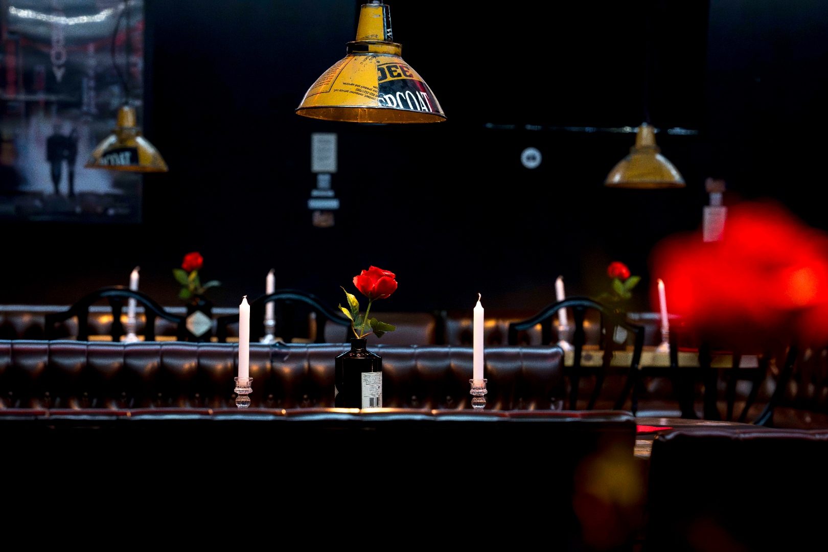 Mesas con velas y rosas en Miles Cocktail Lounge